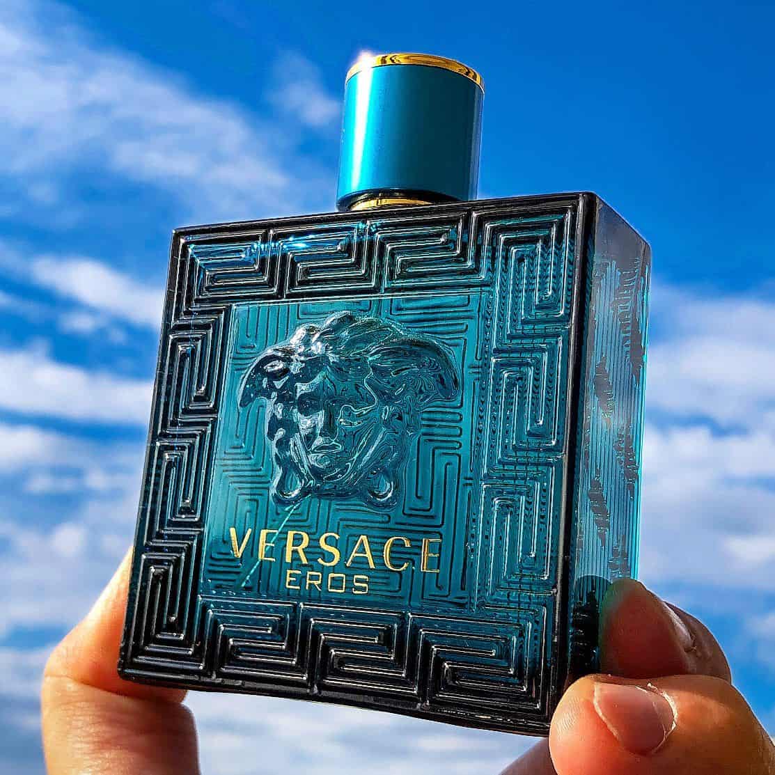 holding a bottle of versace eros