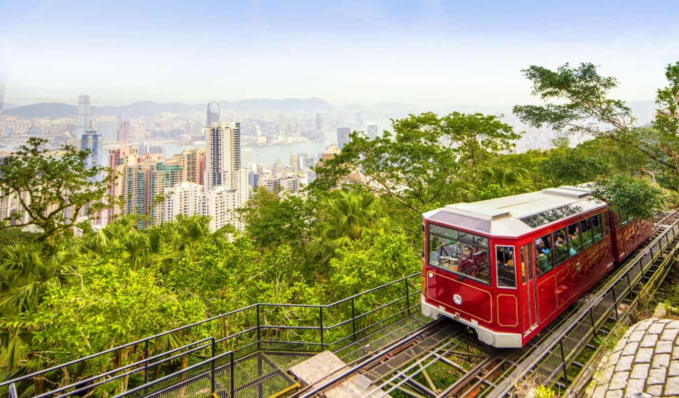 The red Peak Tram with the skyscrapers of Hong Kong in the background